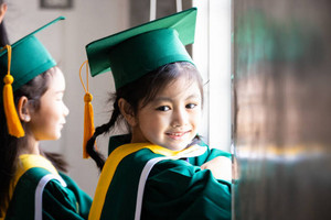 little girl wearing graduation gear