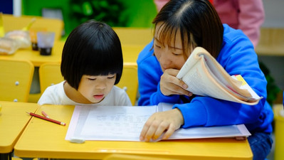 Teacher looking at resources with student at desk